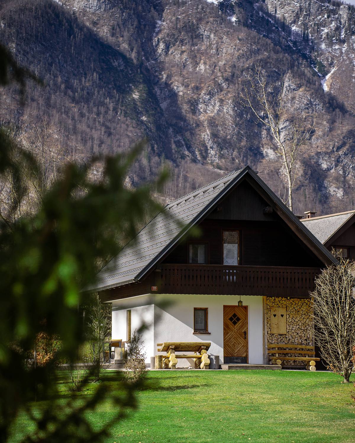 The first of the four houses, below a snow-streaked ridge